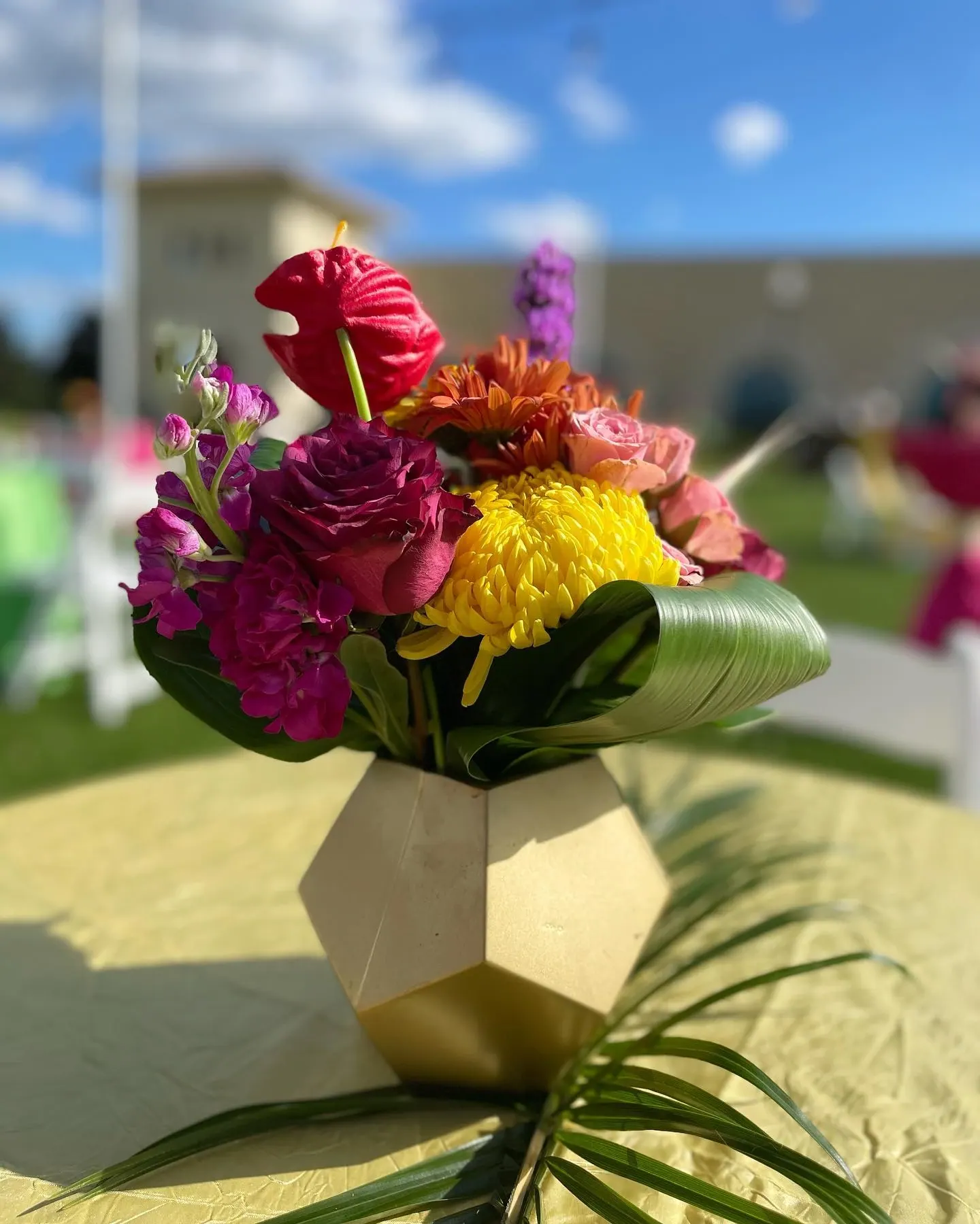 Vibrant magenta and yellow centerpiece in geometric vase