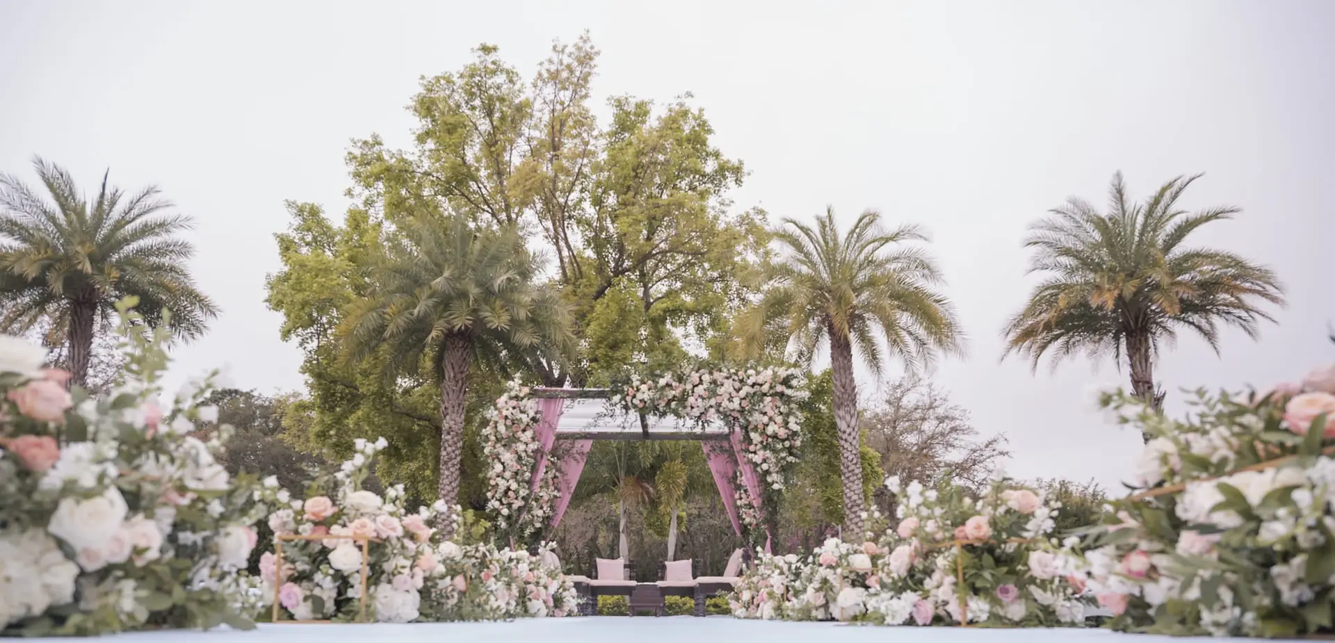 Wide ceremony under a floral mandap with cascading blooms
