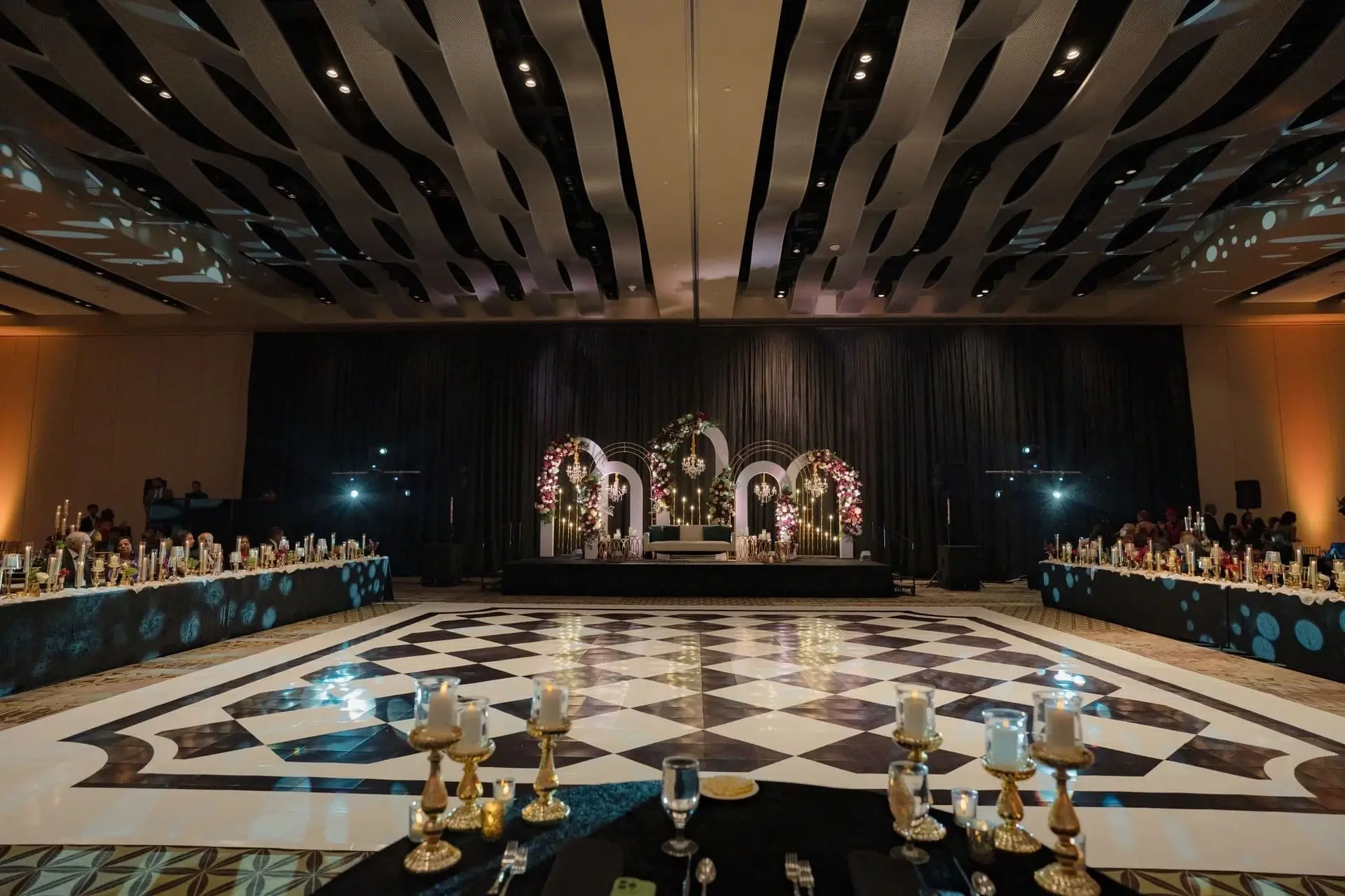 Welcome lounge styled with candles, brass, and seasonal florals